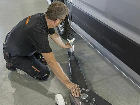 Die Tragarme werden von außen unter die Fahrzeug-Aufnahmepunkte geschwenkt